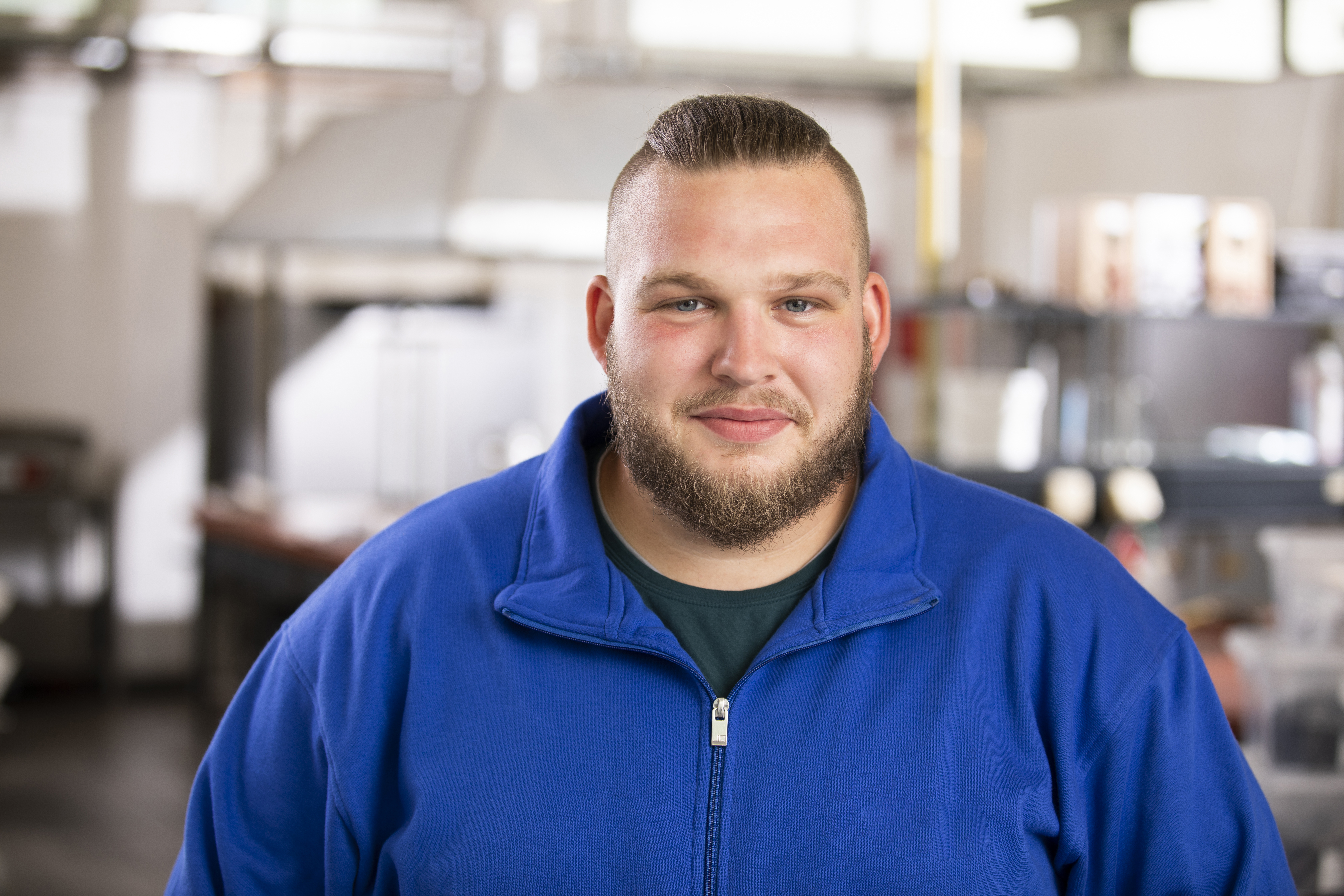 Baustoffprüfer mit einem blauen Pullover schaut frontal in die Kamera.
