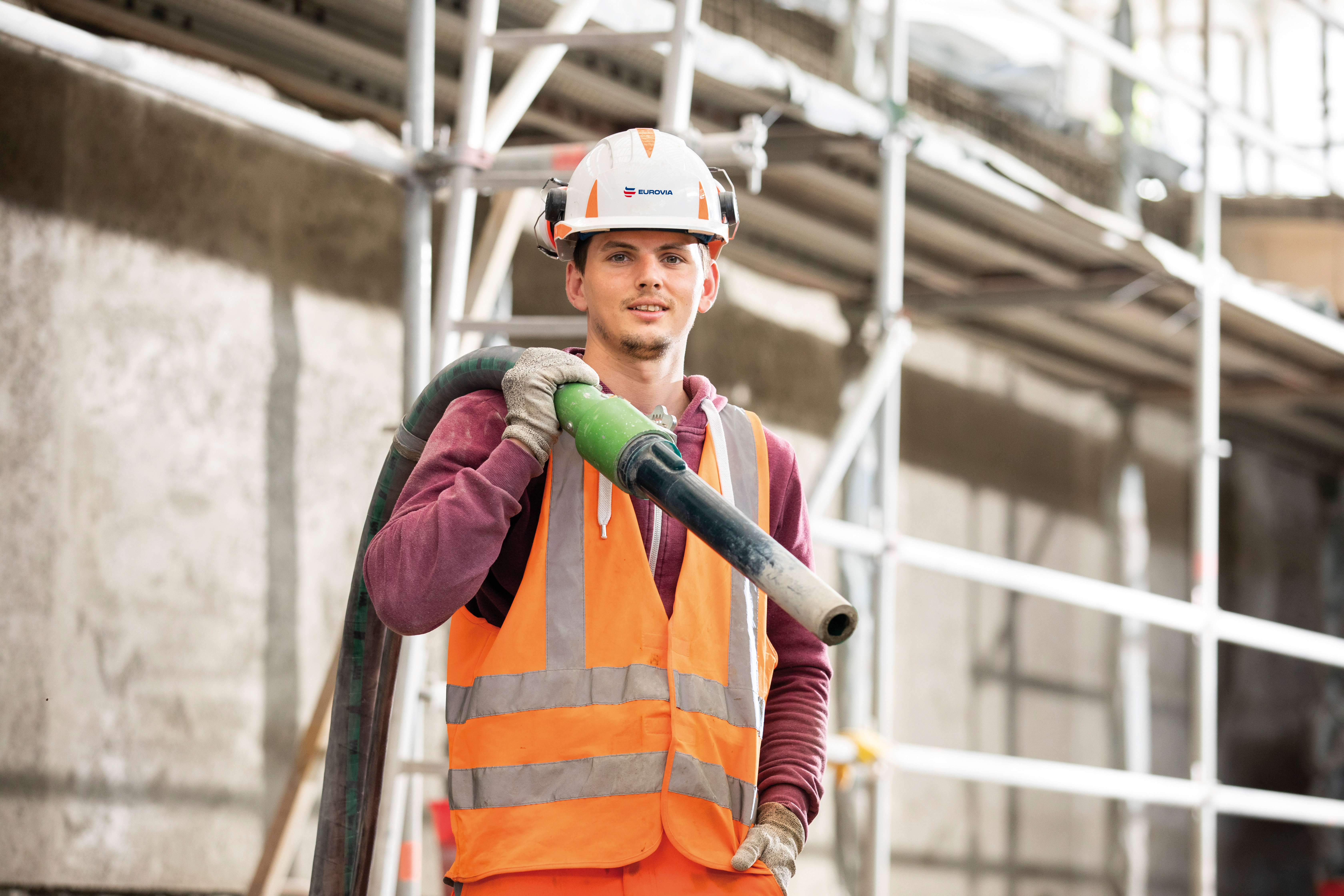Beton-/Stahlbauer trägt PSA bei der Arbeit. 