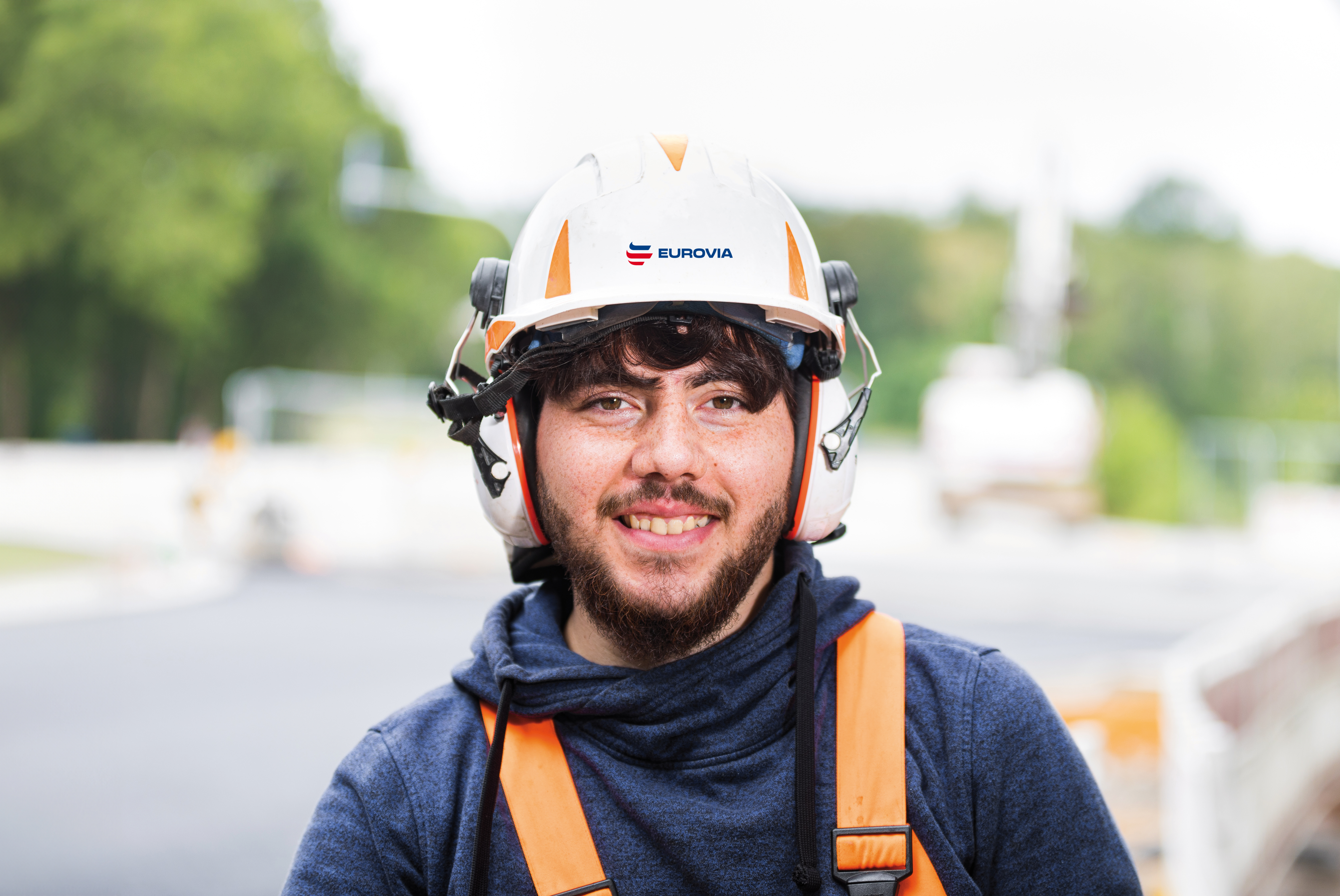 Mann trägt einen weißen Helm und Ohrschützer.