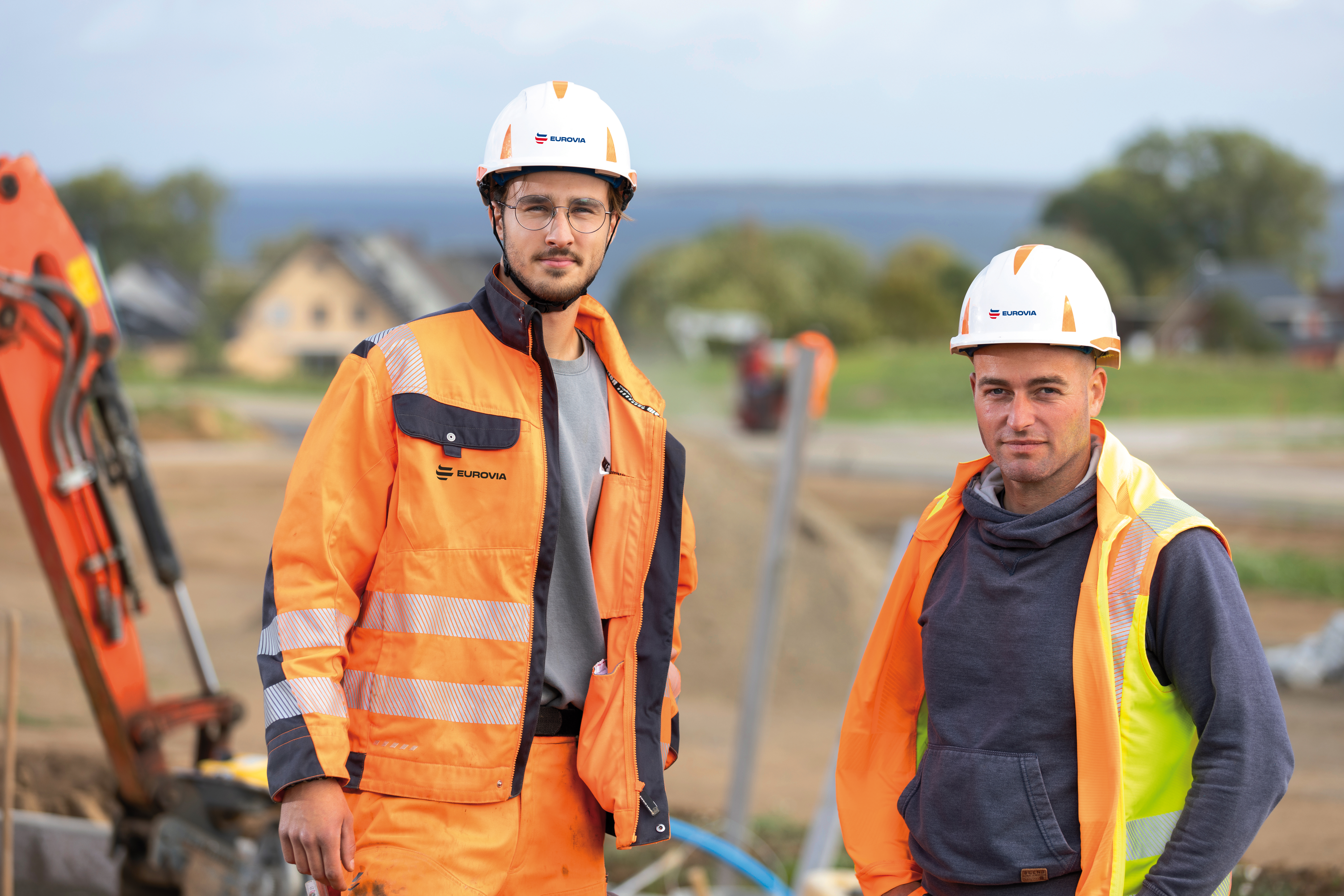 Zwei Rohrleitungsbauer in PSA schauen frontal.