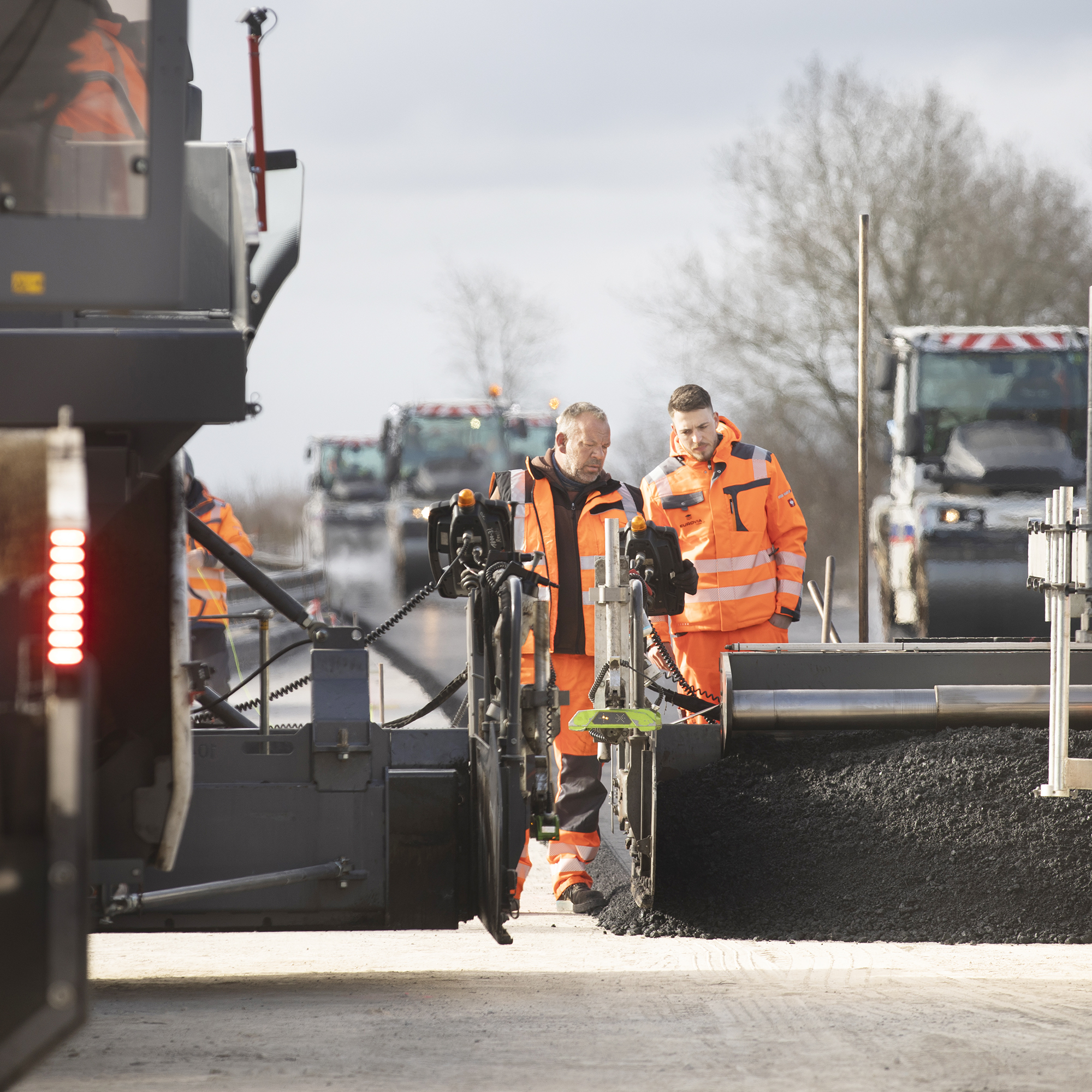 Mitarbeiter arbeiten in PSA-Kleidung auf einer Baustelle.