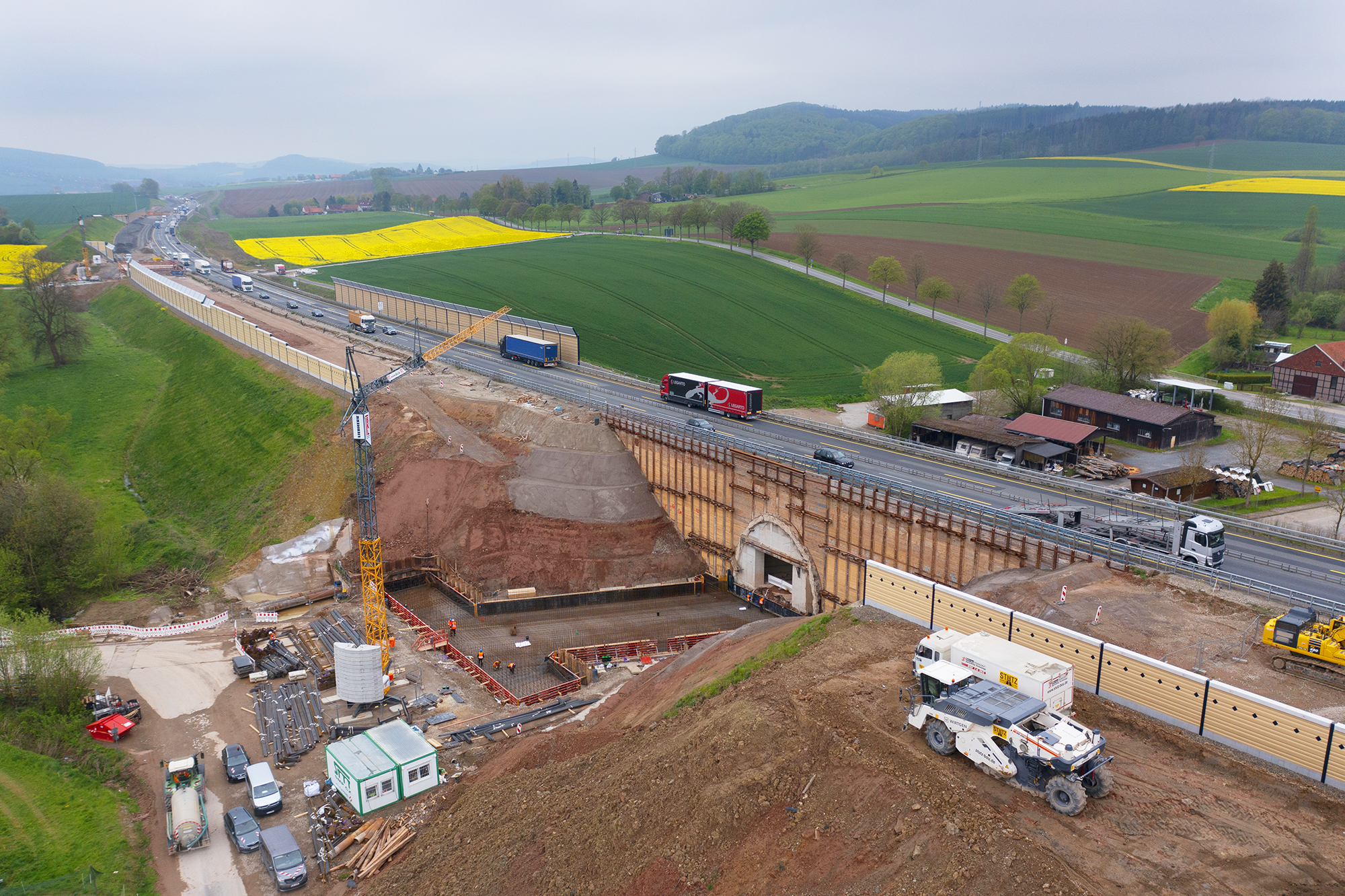 Luftaufnahme von Bauarbeiter und Maschinen im Einsatz auf einer Baustelle.