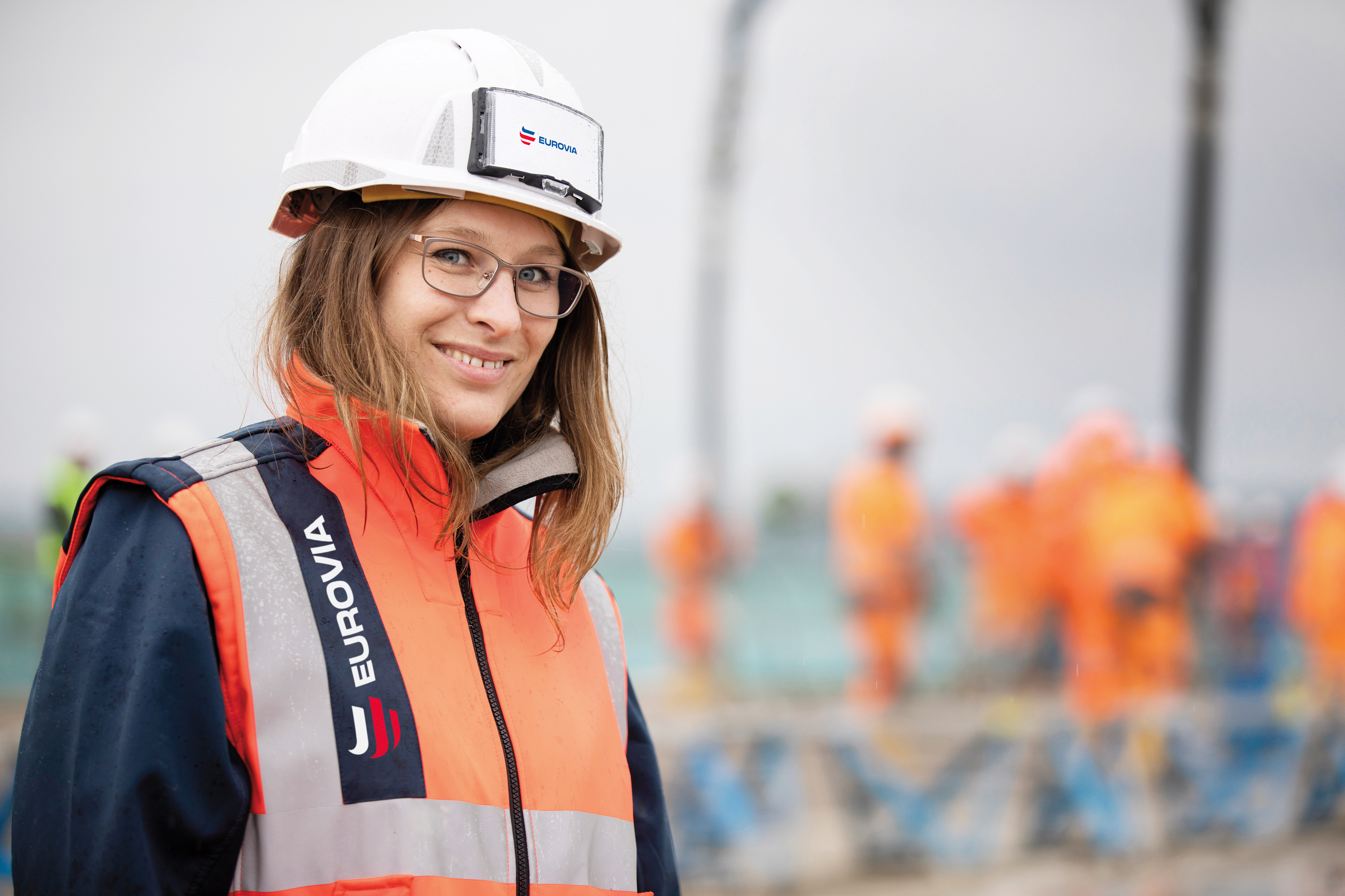 Frau trägt eine orange Warnweste mit der Aufschrift