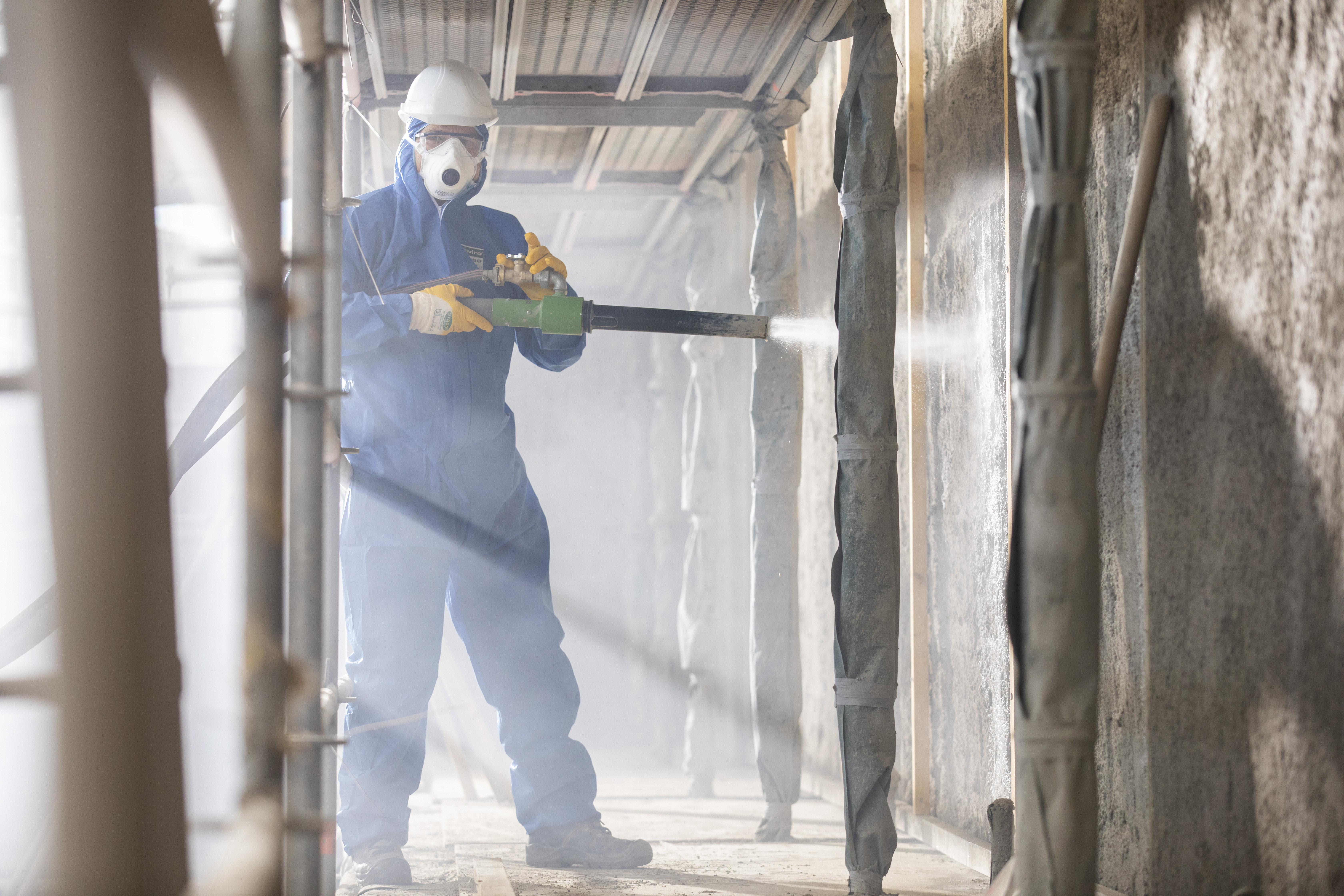 Mann arbeitet in einem blauen Ganzkörperanzug.