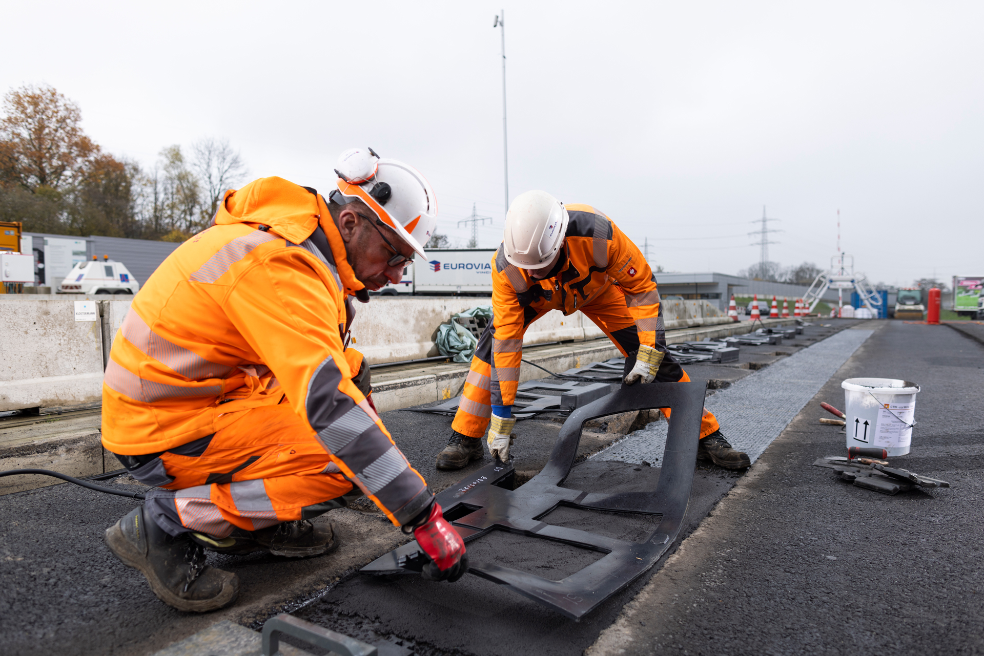 Zwei Bauarbeiter in PSA verlegen die E-Charge-Teststrecke.