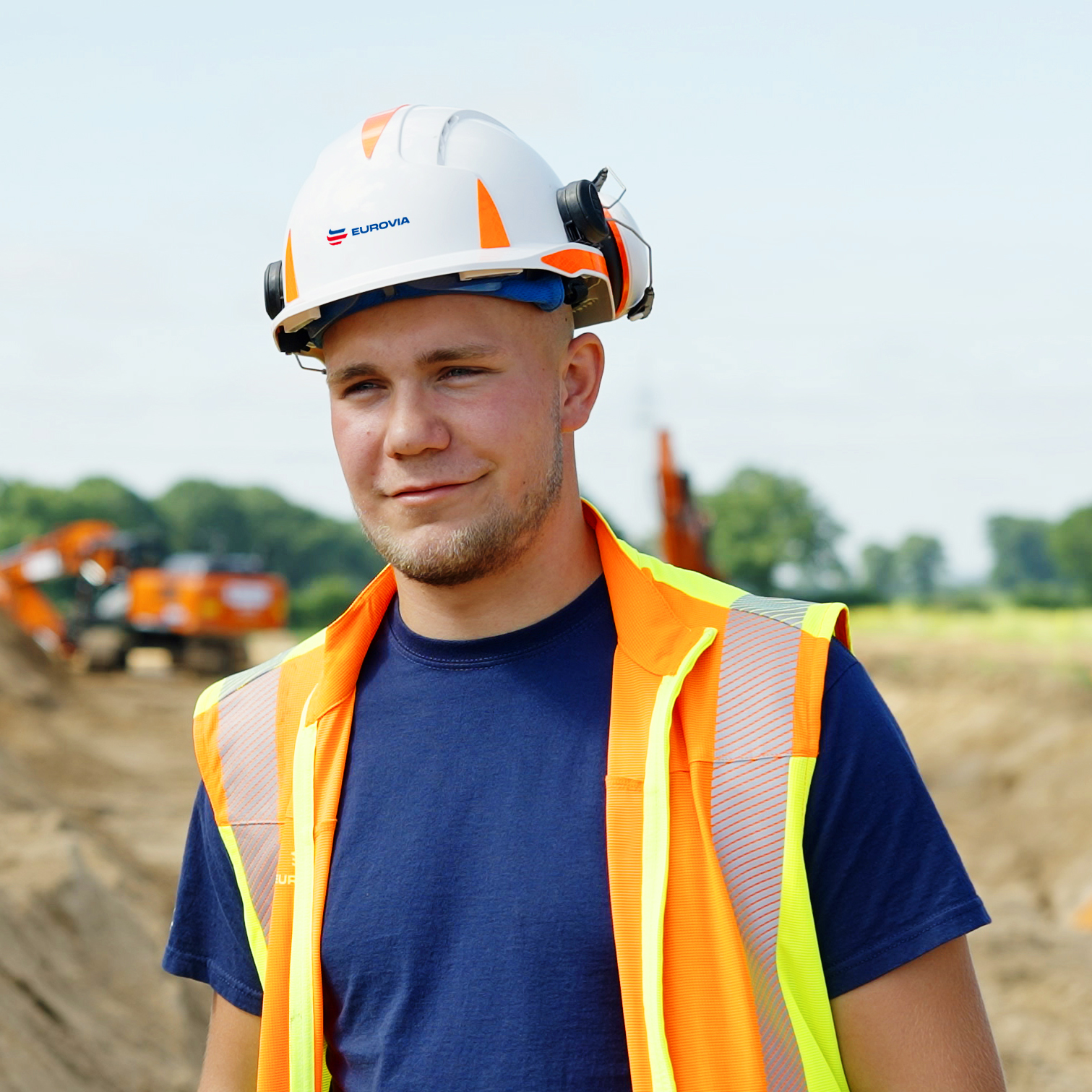 Azubi mit Warnschutzweste und Helm.