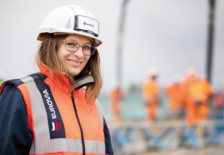Frau trägt eine orange Warnweste mit der Aufschrift 